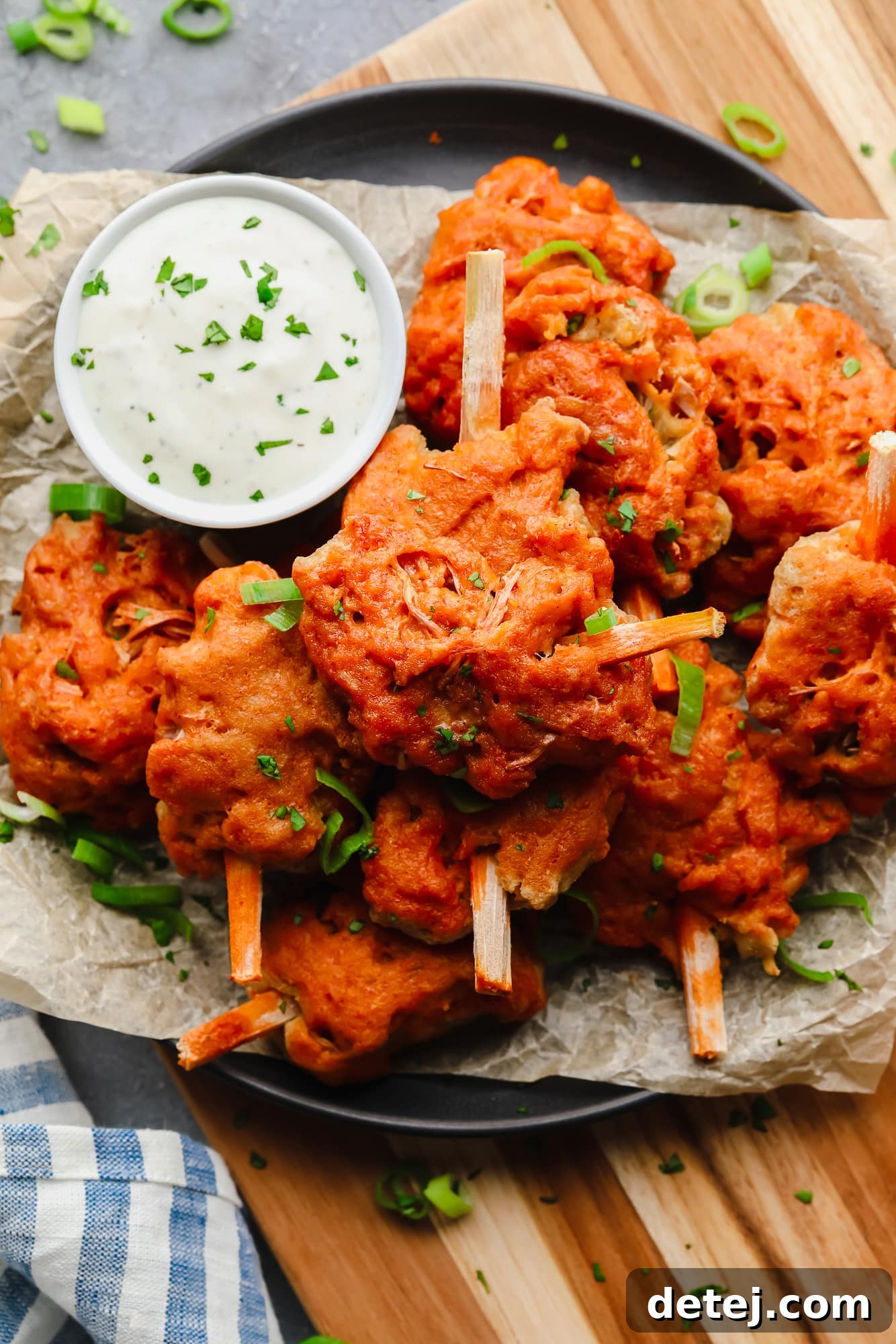 Wingless Wonders 2 A vibrant plate of perfectly cooked vegan wings, generously coated in sauce, with a small bowl of creamy dipping sauce nearby. A true game-day favorite.