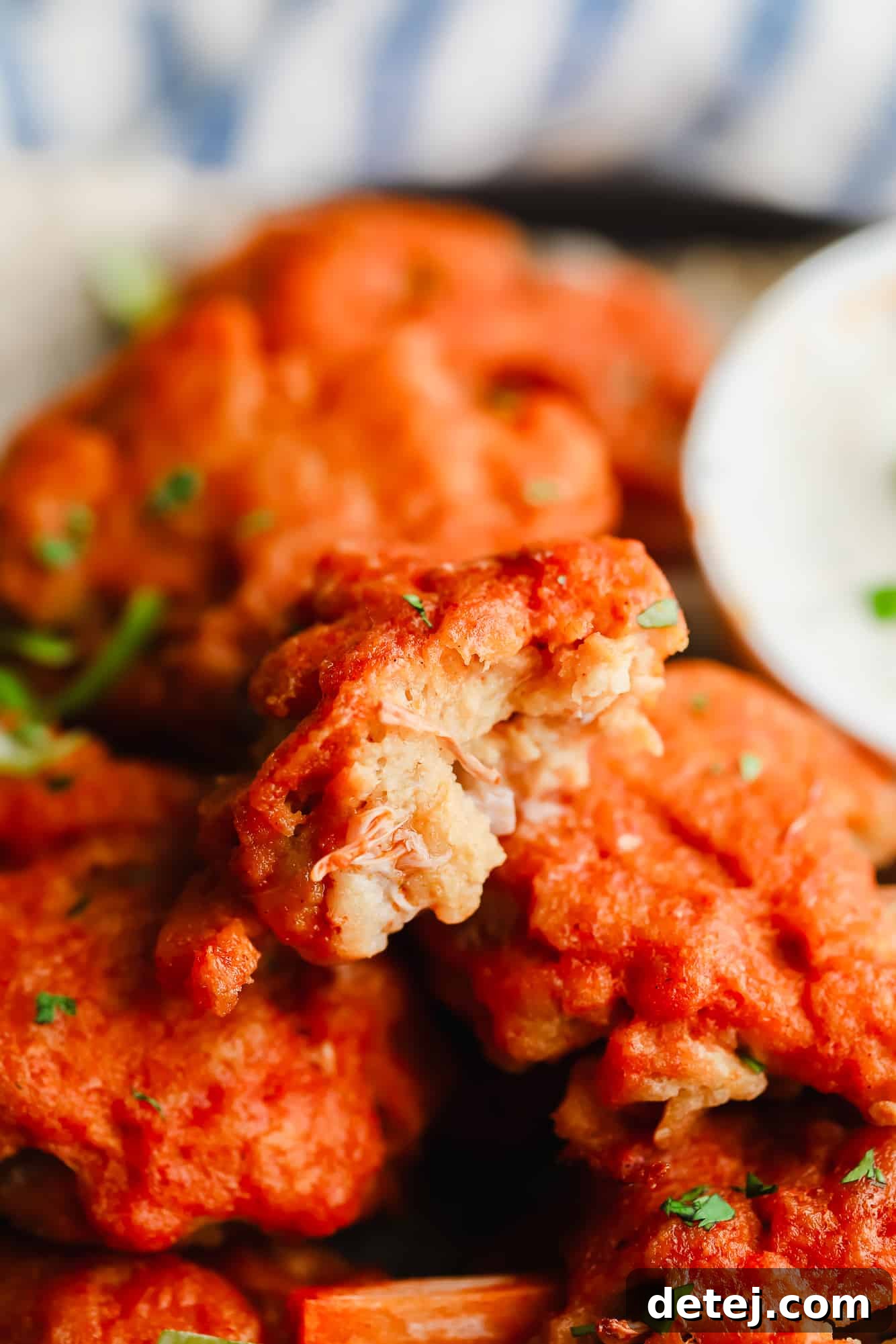 Wingless Wonders 11 A close-up of a succulent vegan wing, showing its authentic meaty texture with a bite taken out, revealing the moist interior.