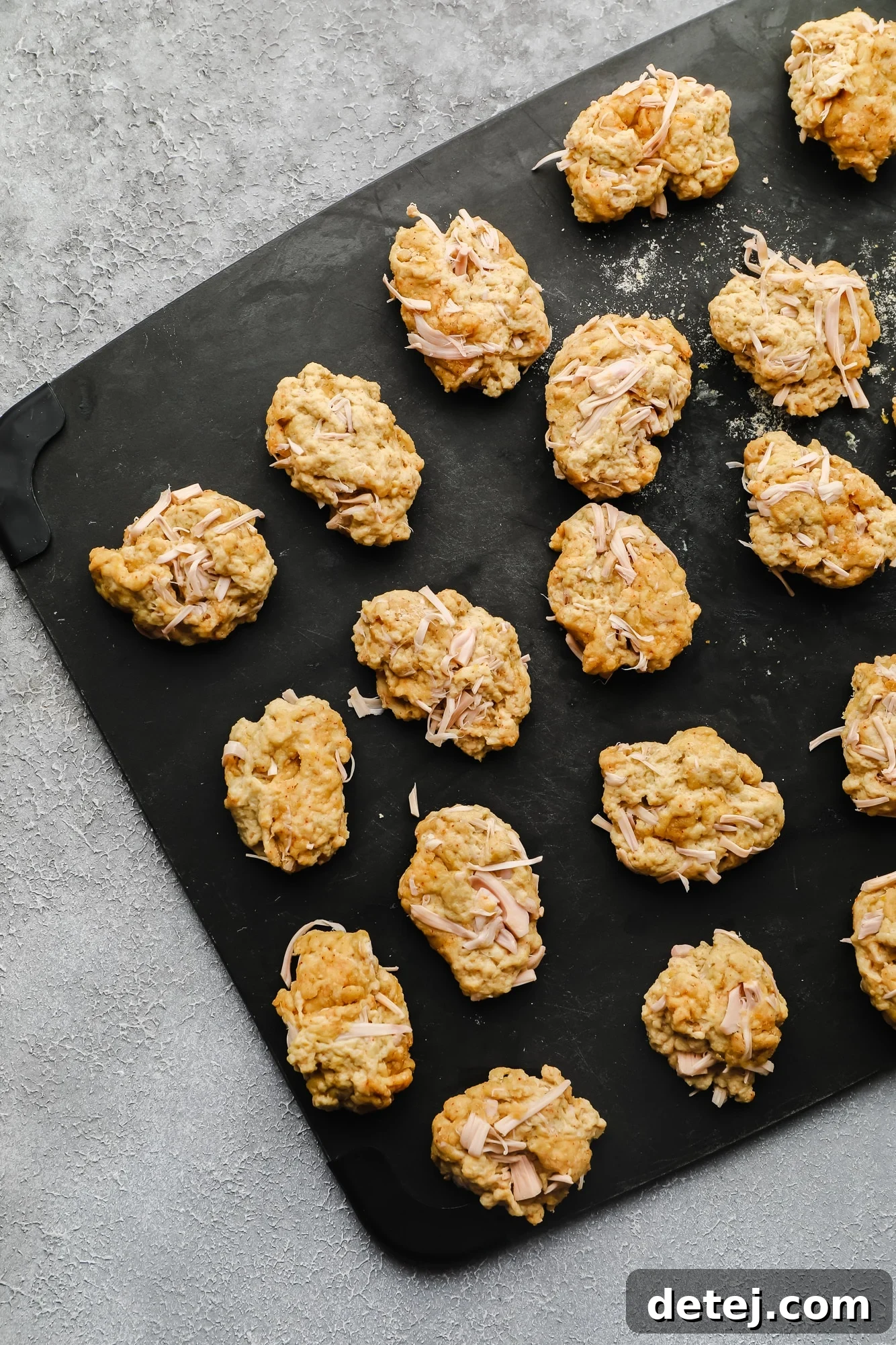 Wingless Wonders 7 Uncooked, raw vegan wing pieces, freshly cut and shaped, resting on a black cutting board before the boiling process.