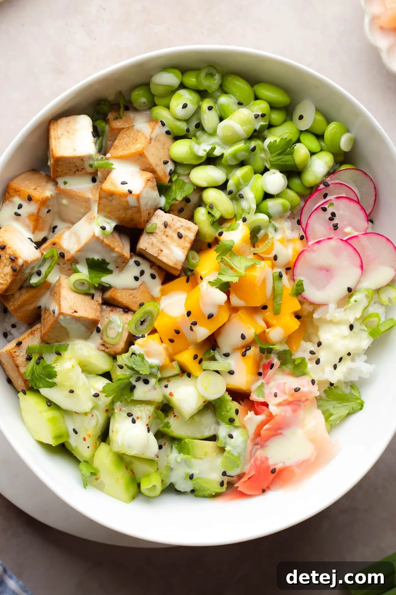 close up on tofu poke bowl with many ingredients on beige background