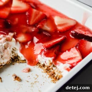 Square image of a delightful strawberry pretzel dessert in a pan, showcasing its appealing layers.