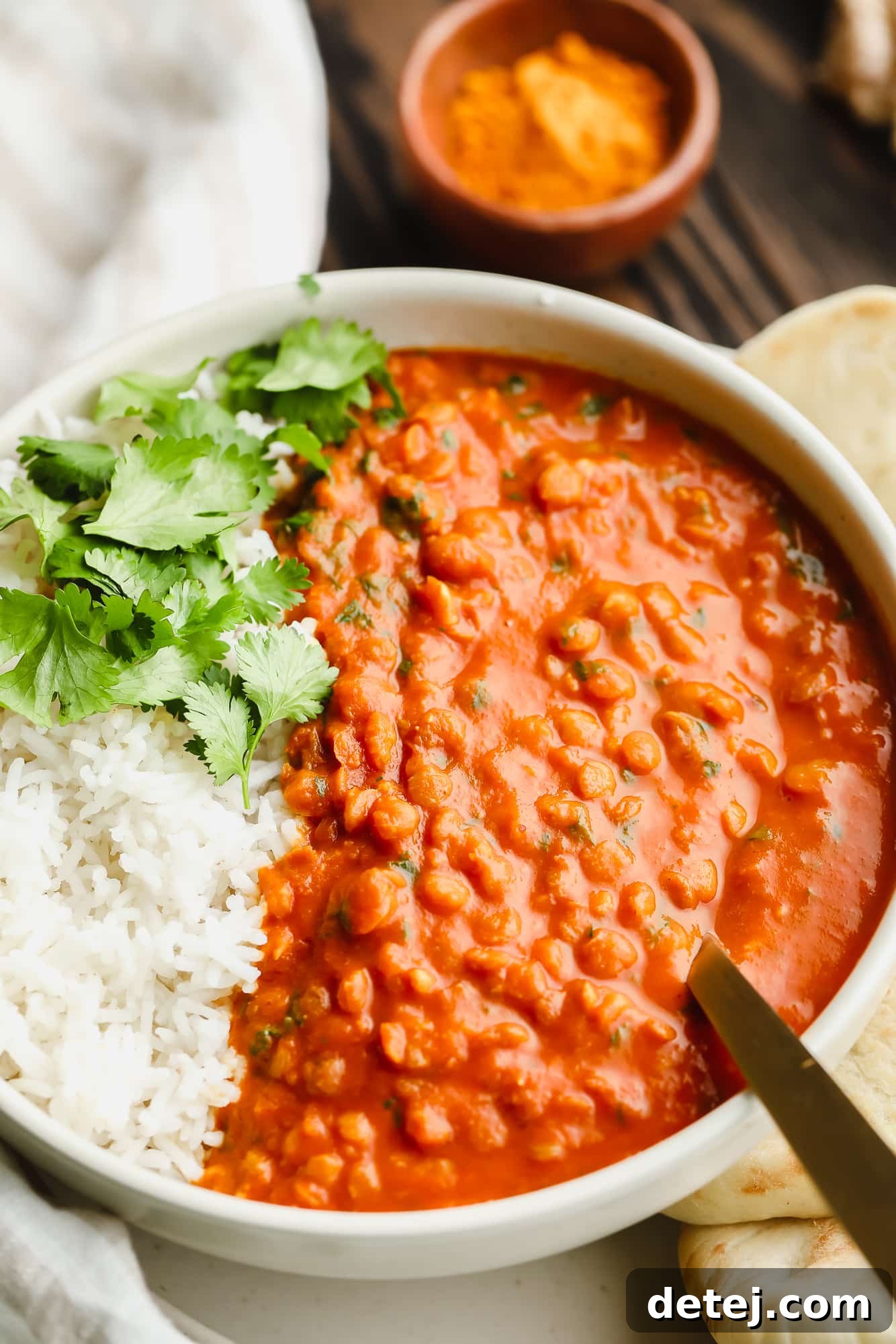 Another close-up of the rich lentil curry served with white rice in a clean white bowl, showcasing the inviting texture.