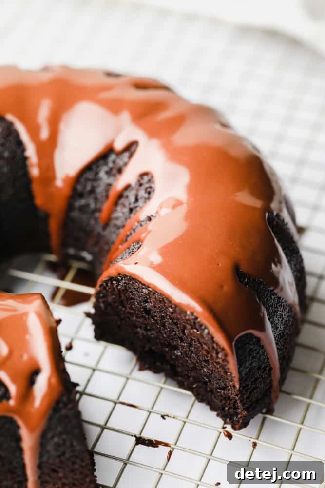 A slice removed from a chocolate vegan bundt cake, revealing its moist and rich interior