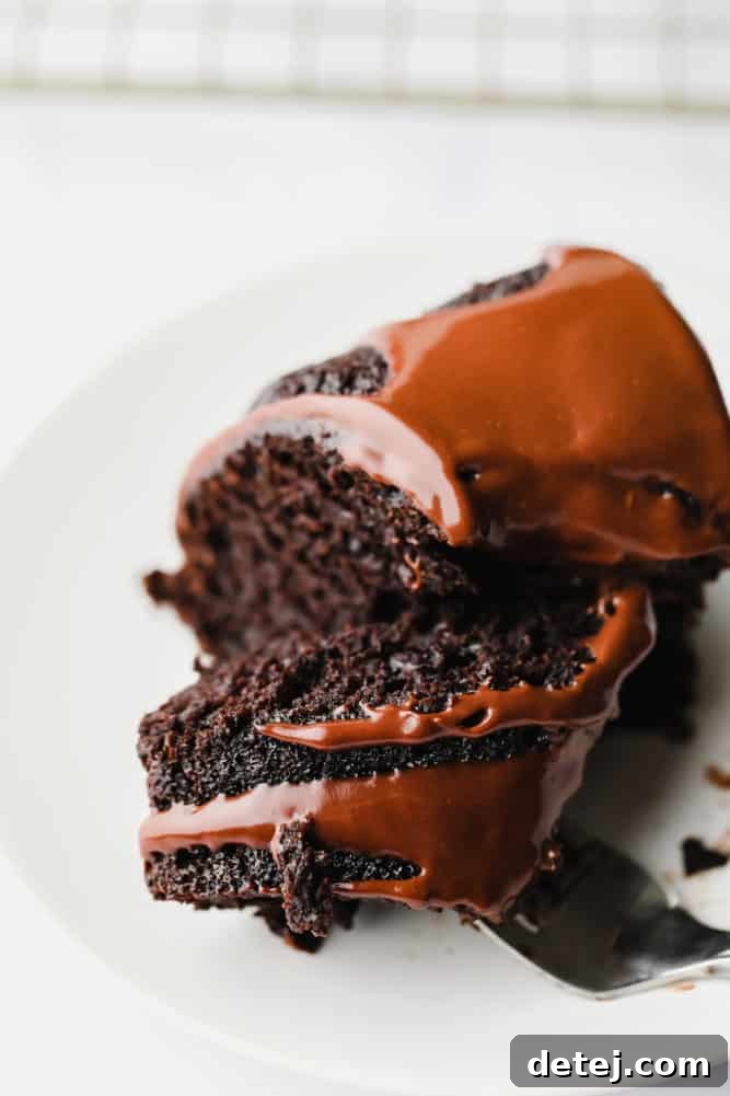 A delicious piece of vegan chocolate bundt cake on a fork, showing the moist texture and ganache