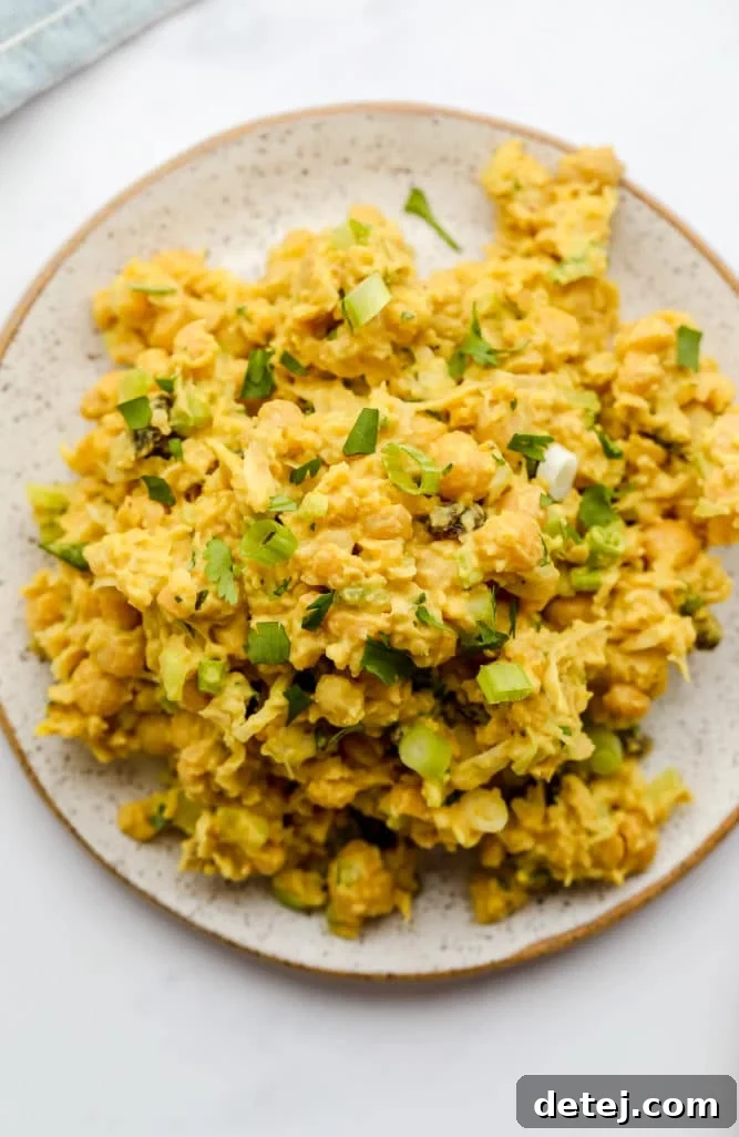curry chickpea salad on a plate with green onions sprinkled