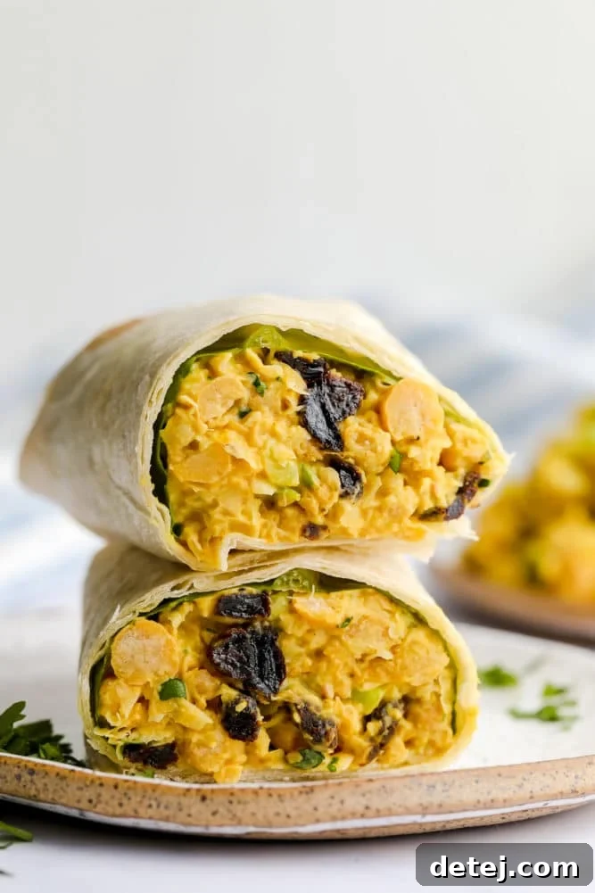 wrap cut in half with curry chickpea salad on a plate