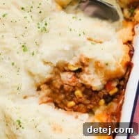 A square image depicting a hearty vegan shepherd's pie, rich with mashed potatoes and a savory plant-based filling.