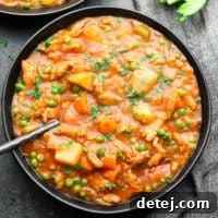 A square image of a steaming bowl of classic vegan stew, rich with vegetables and hearty 'beef' chunks.