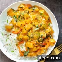 Vibrant Thai pumpkin curry, vegan, with tender pumpkin, tofu, and fresh vegetables in a rich coconut milk broth.