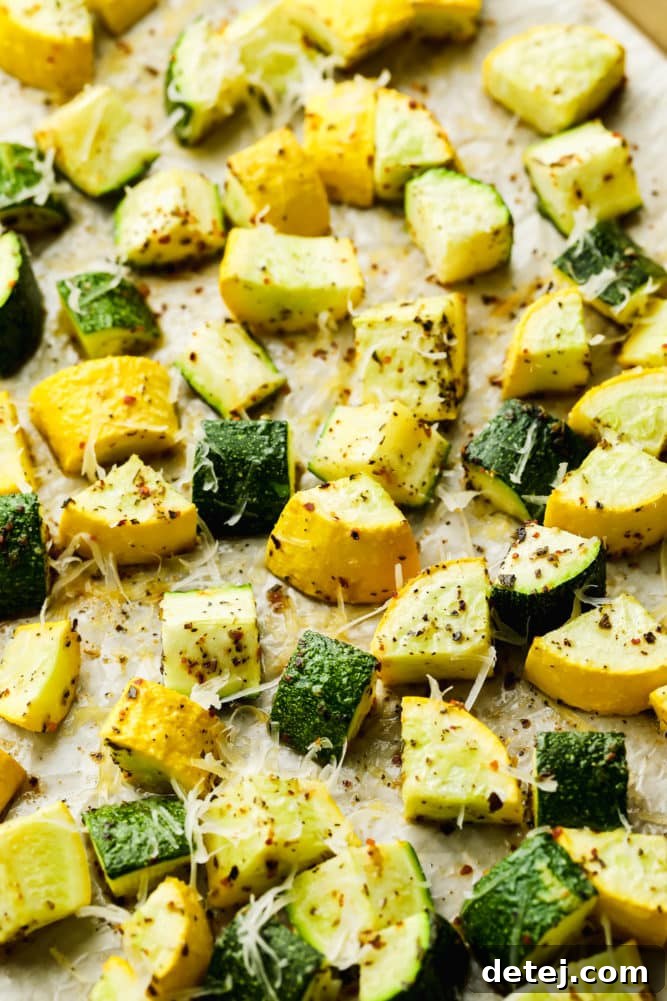 Yellow squash and zucchini roasted with vegan parmesan cheese on tan parchment paper