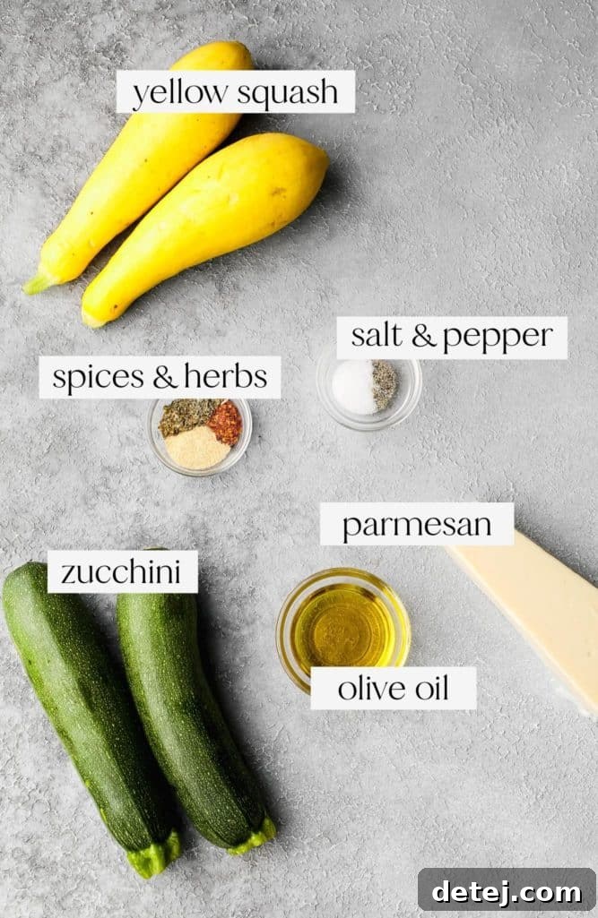 Grey background with whole yellow squash and zucchini, spices, salt, pepper, parmesan, and olive oil