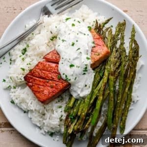 vegan salmon with lemon dill sauce on a plate with rice and asparagus.
