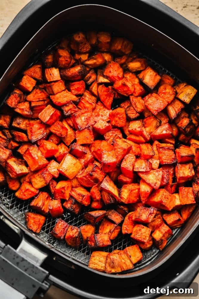 blackened and golden air fryer sweet potatoes in the basket.