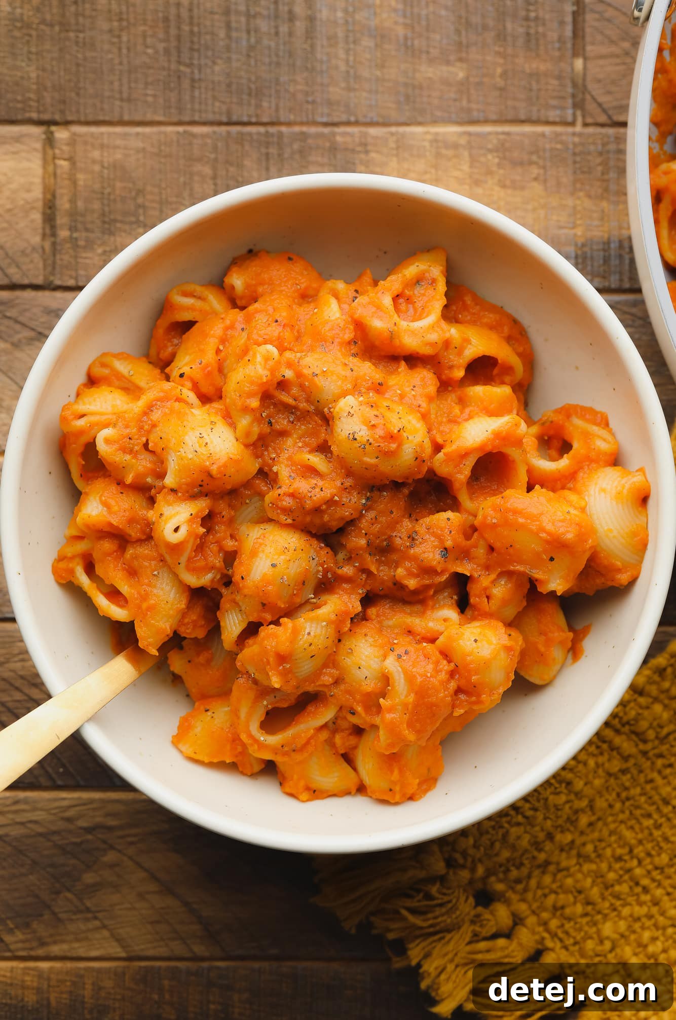 a white bowl filled with pasta covered in pumpkin pasta sauce.