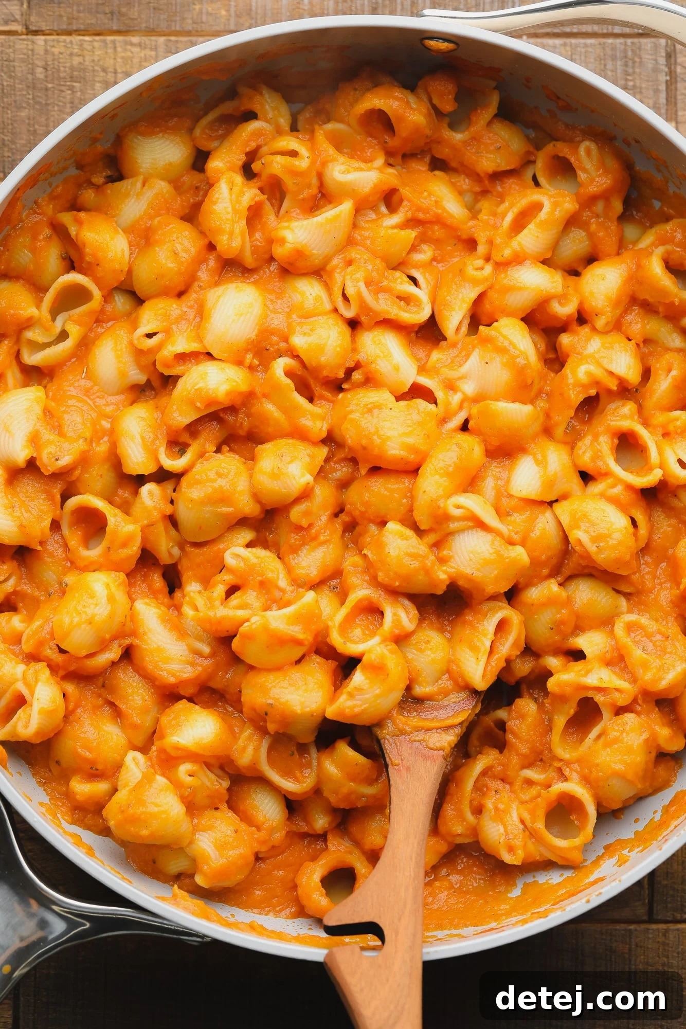pasta noodles covered in pumpkin pasta sauce in a large skillet.