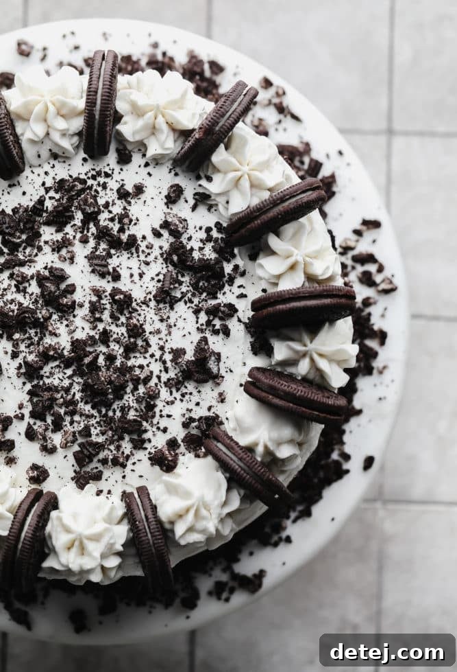 top of an oreo cake showing piped frosting and oreos on a cake stand.