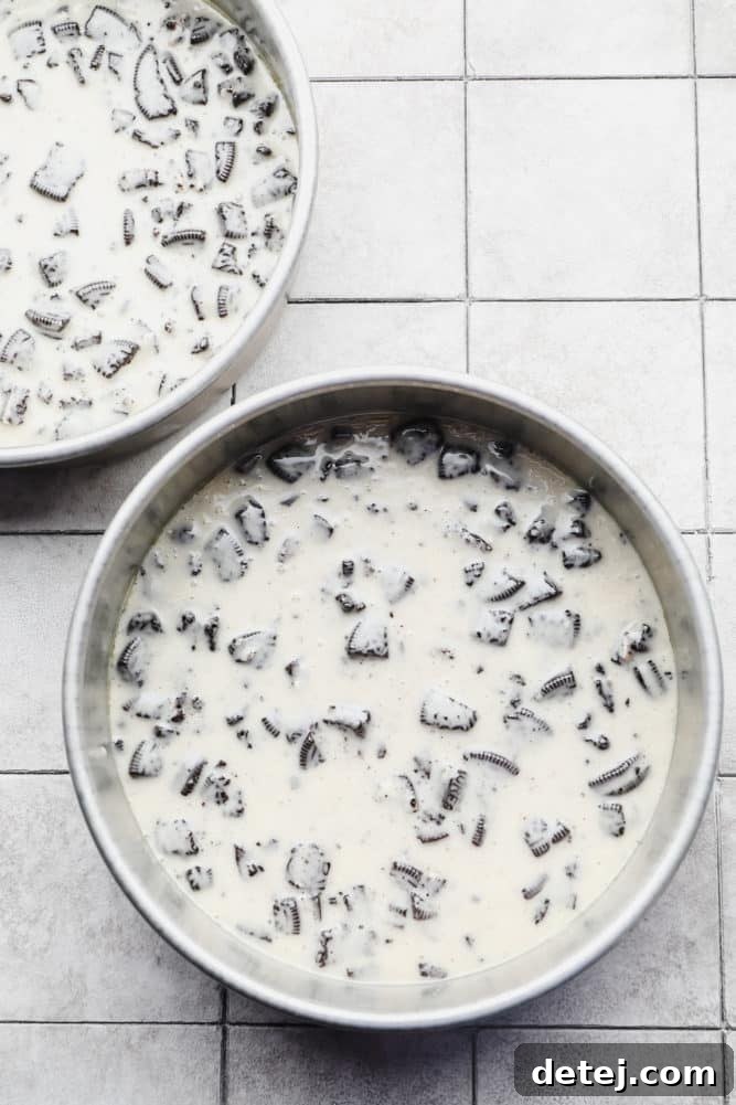 uncooked oreo cake batter in two round pans.