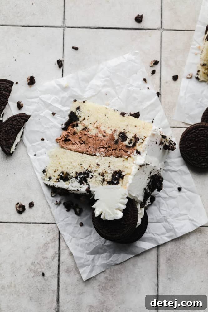 looking down on a piece of cake with whipped chocolate frosting on grey tile background.