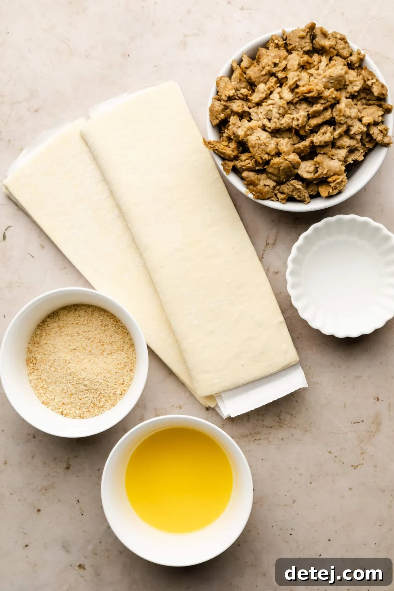 A collection of ingredients for vegan sausage rolls, neatly arranged in separate white bowls, highlighting their simplicity.