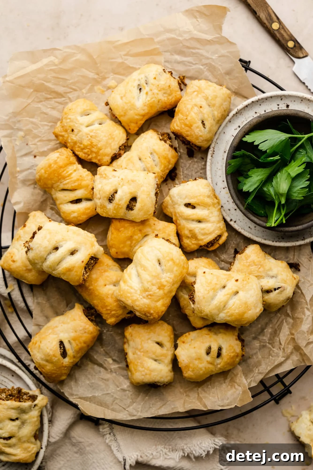 A stunning platter of golden-baked vegan sausage rolls, meticulously arranged on parchment paper, ready to be devoured.