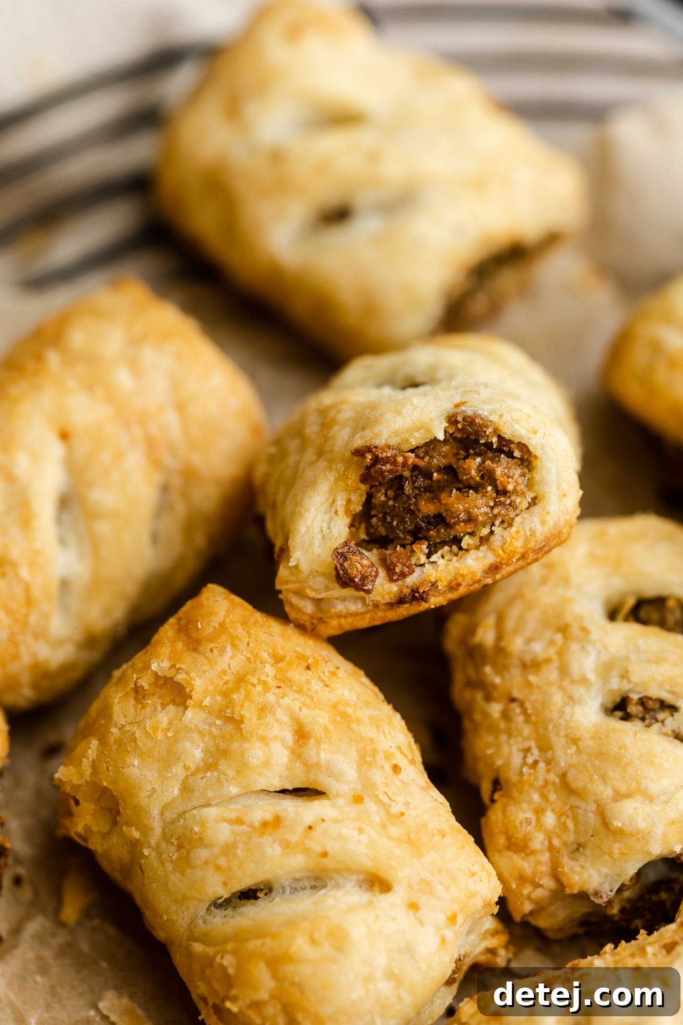 A close-up view of a perfectly baked vegan sausage roll, showcasing its golden, flaky crust and appetizing filling.