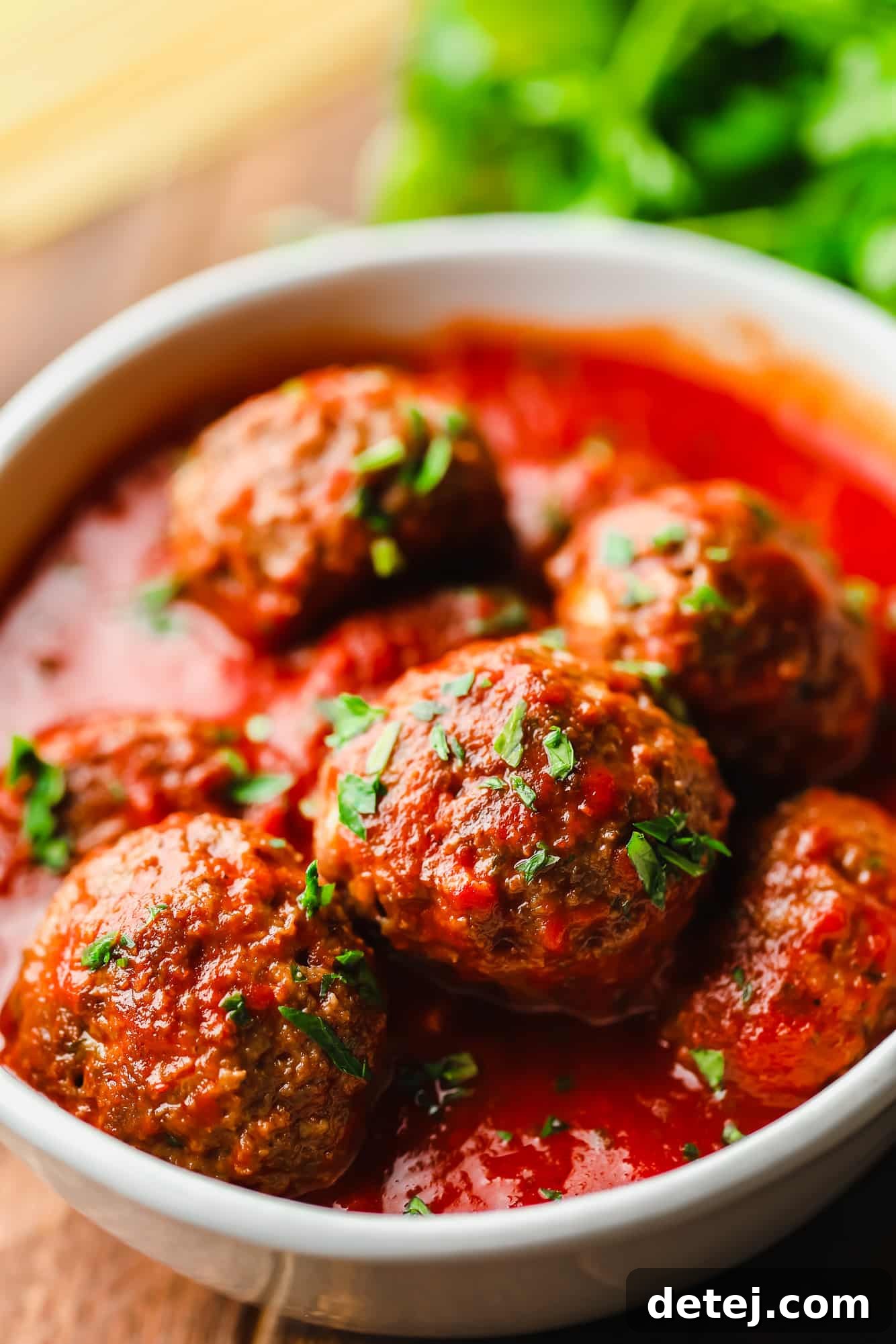 Next-Gen Meatballs 2 Vegan meatballs covered in rich marinara sauce, artfully arranged in a pristine white bowl.