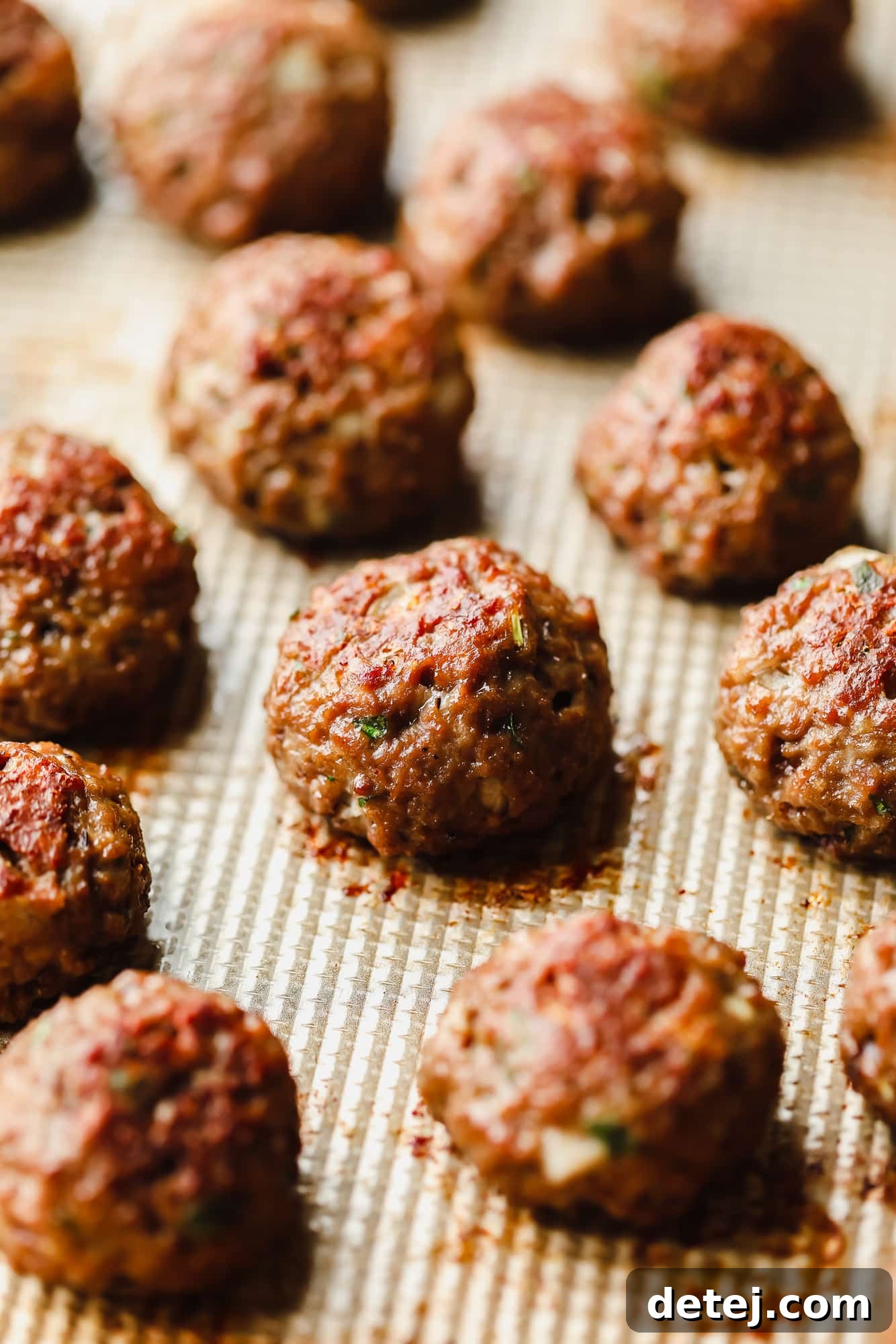 Next-Gen Meatballs 3 Close-up view of multiple rows of perfectly baked vegan meatballs arranged neatly on a baking sheet, golden brown and ready to serve.