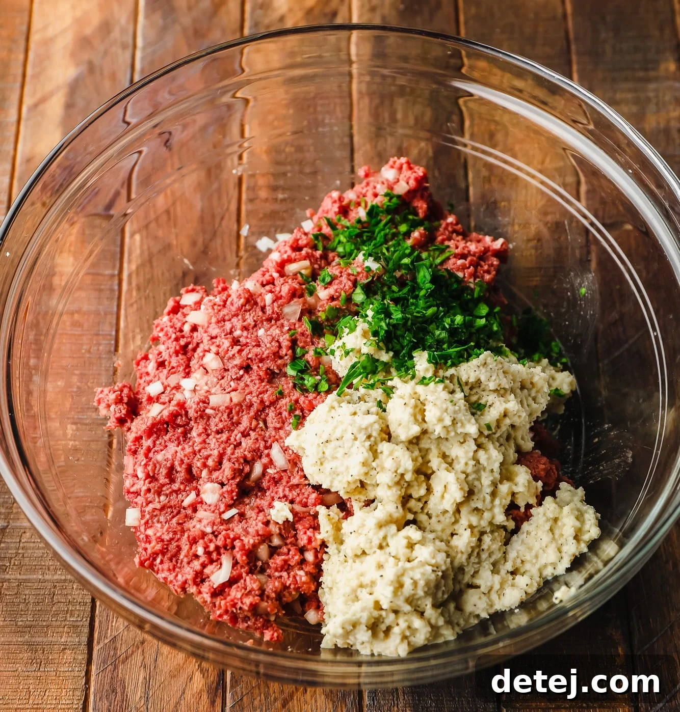 Next-Gen Meatballs 6 All the essential ingredients for vegan meatballs, including Impossible ground beef, breadcrumb mixture, and fresh parsley, harmoniously combined in a large glass bowl, ready for shaping.