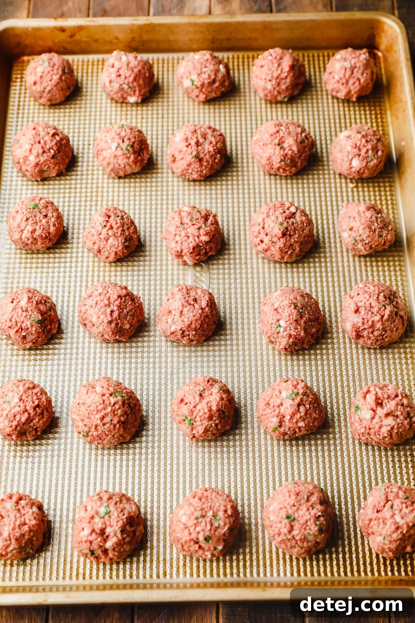 Next-Gen Meatballs 7 Neatly rolled vegan meatballs arranged in perfectly spaced rows on a baking sheet, ready for the oven or freshly baked and golden.