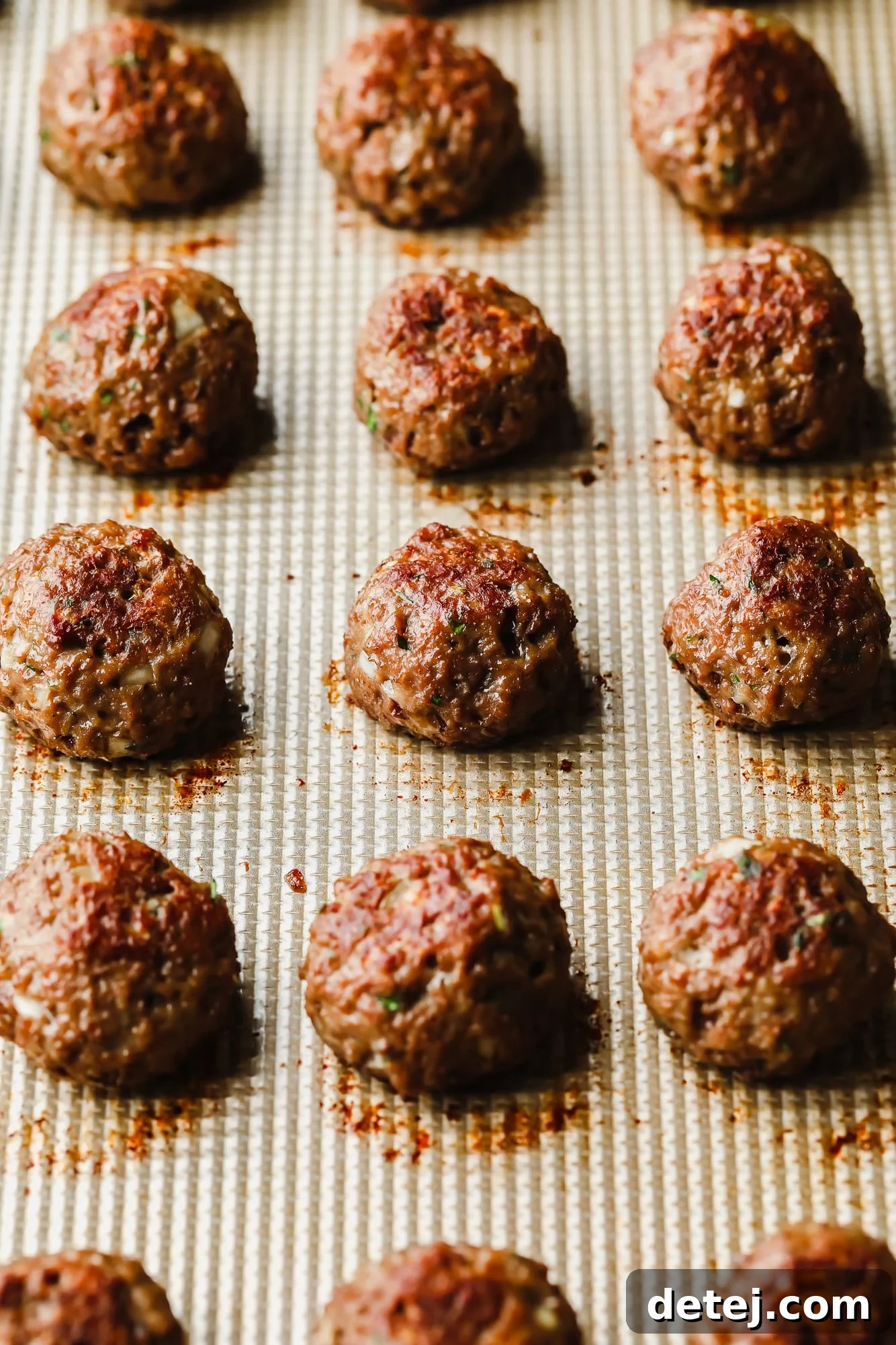 Next-Gen Meatballs 8 Another close-up of baked vegan meatballs on a baking sheet, showcasing their consistent shape and golden-brown exterior.