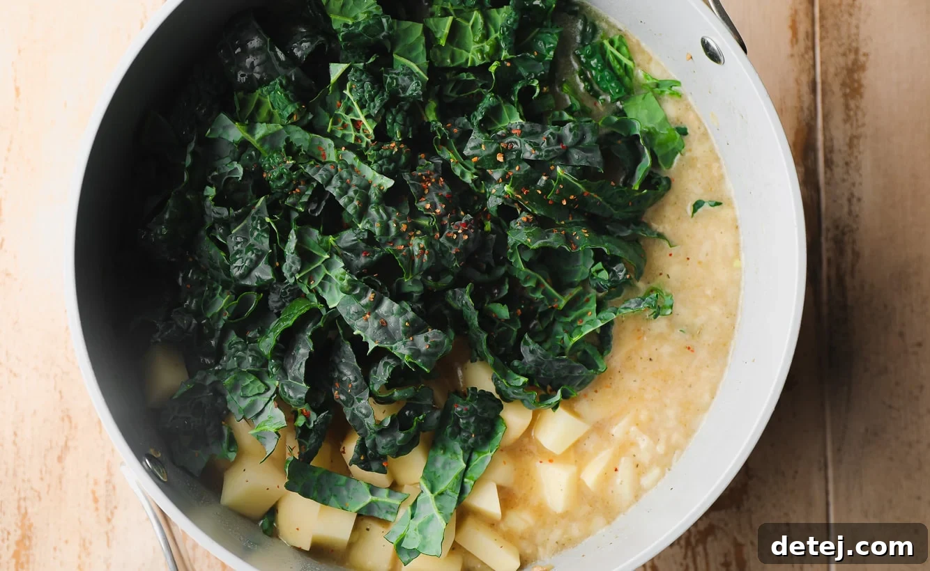 kale, potatoes, and broth in a large grey pot.