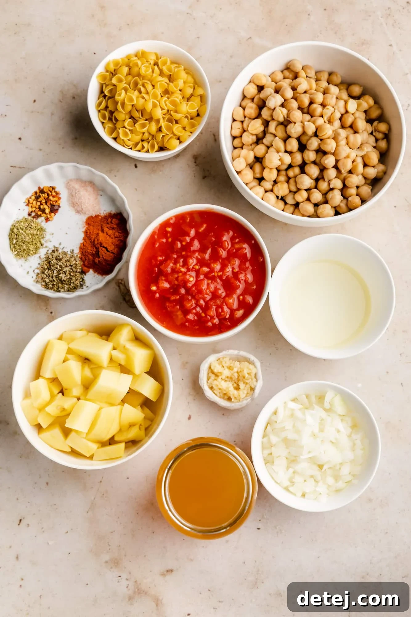 Individual white bowls filled with the ingredients for Italian chickpea soup, neatly arranged to show fresh produce and pantry staples.