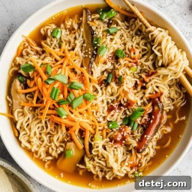 Close up on a white bowl filled with vegan ramen, garnished beautifully with fresh ingredients.