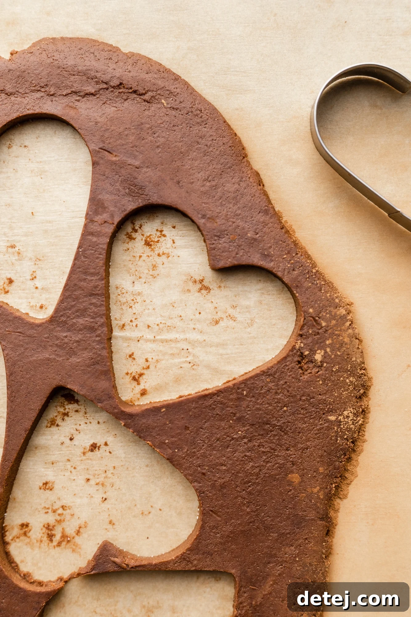 rolled out chocolate cookie dough with heart-shaped holes.