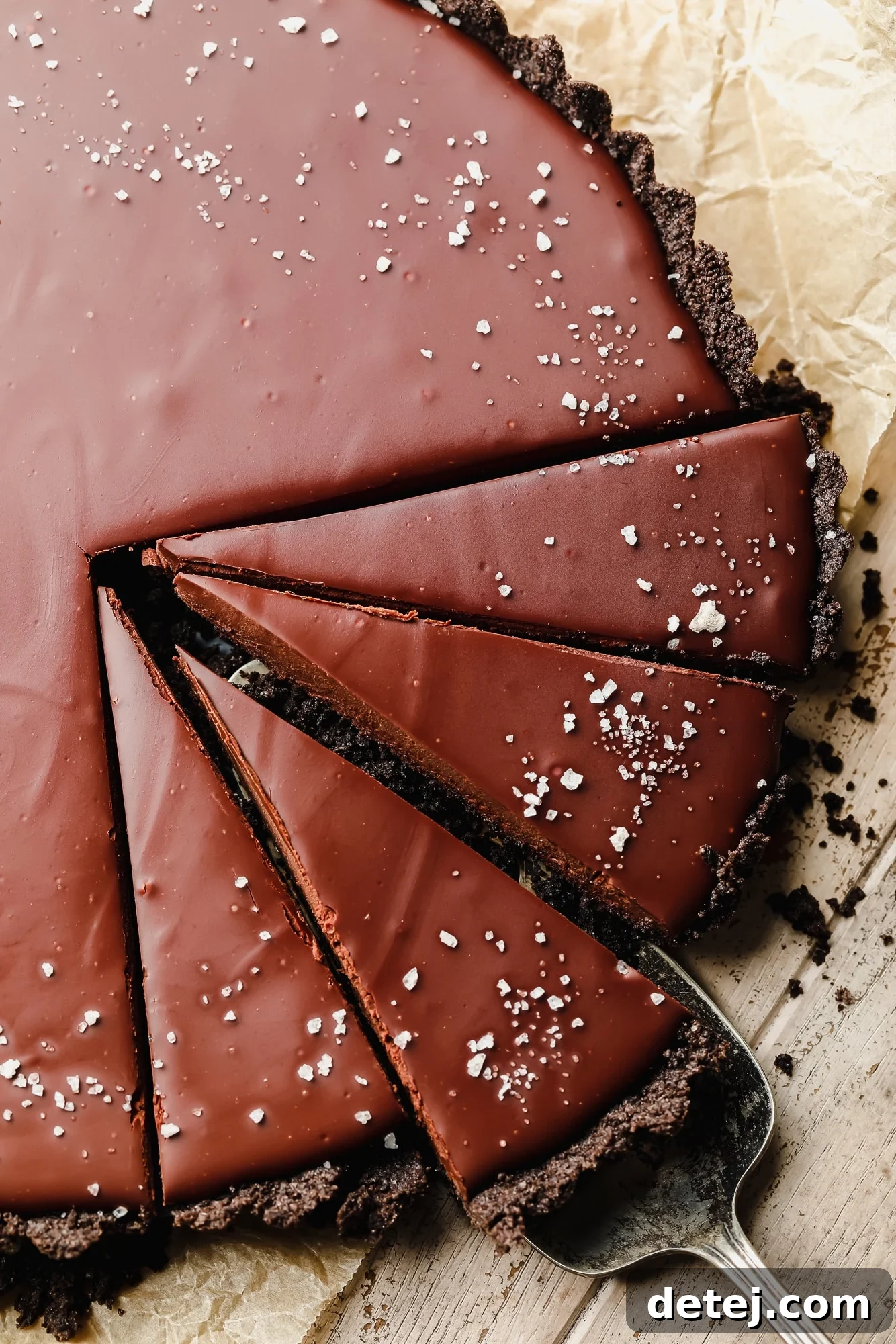 using a cake server to lift up a slice of vegan chocolate tart.