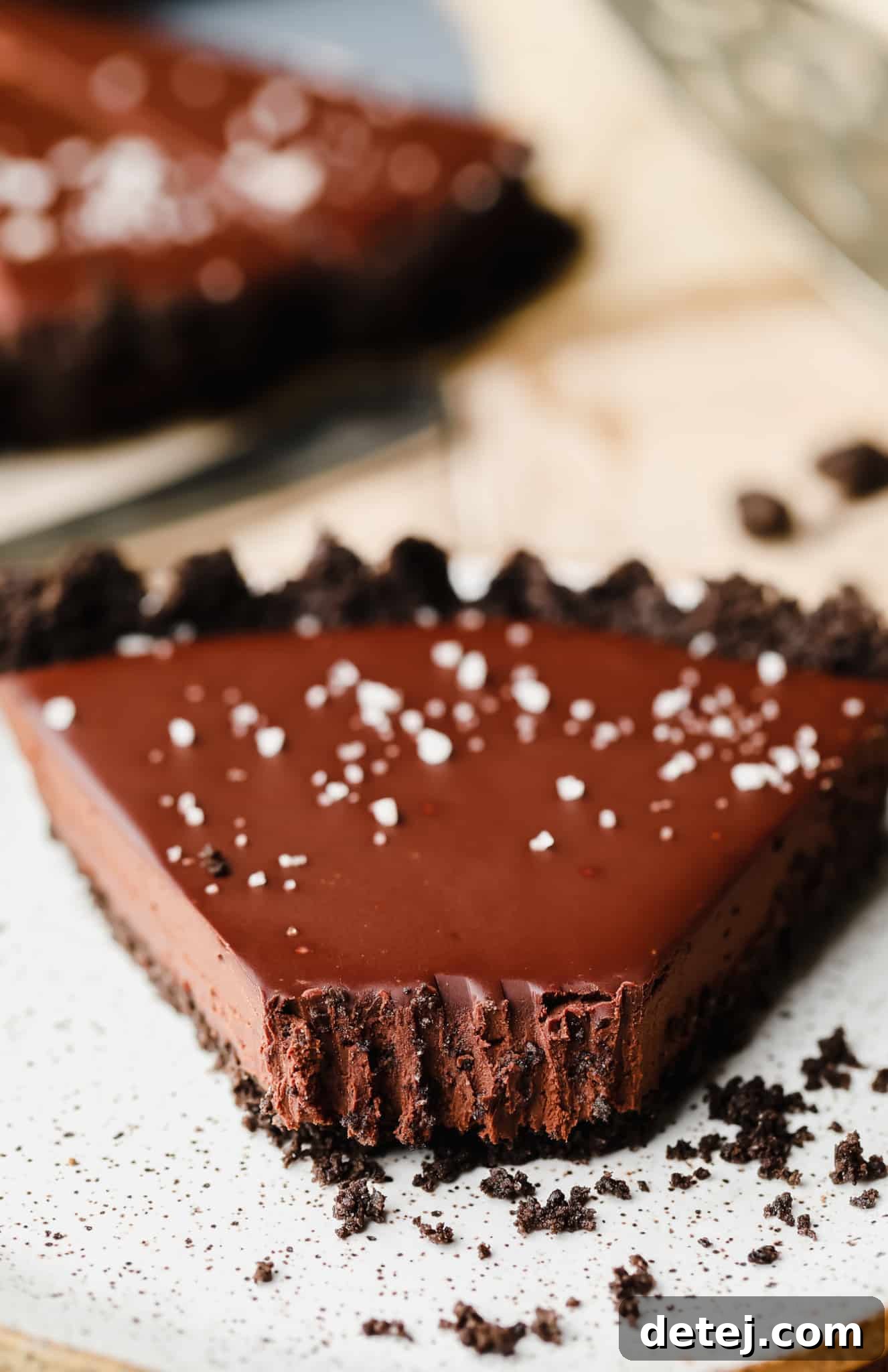 close up on a slice of vegan chocolate tart with a bite missing.