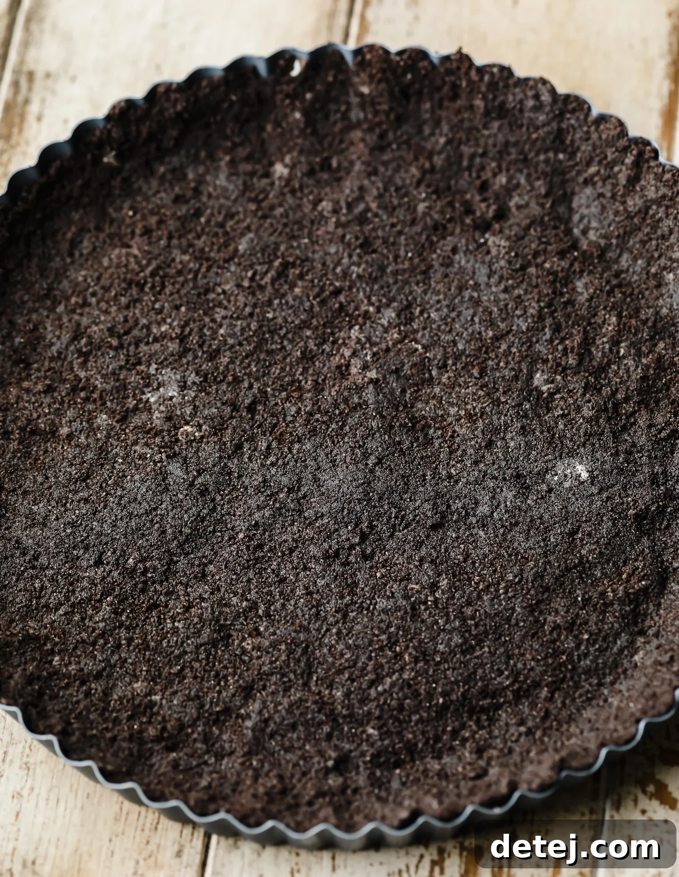 an oreo cookie crust pressed into a tart pan.