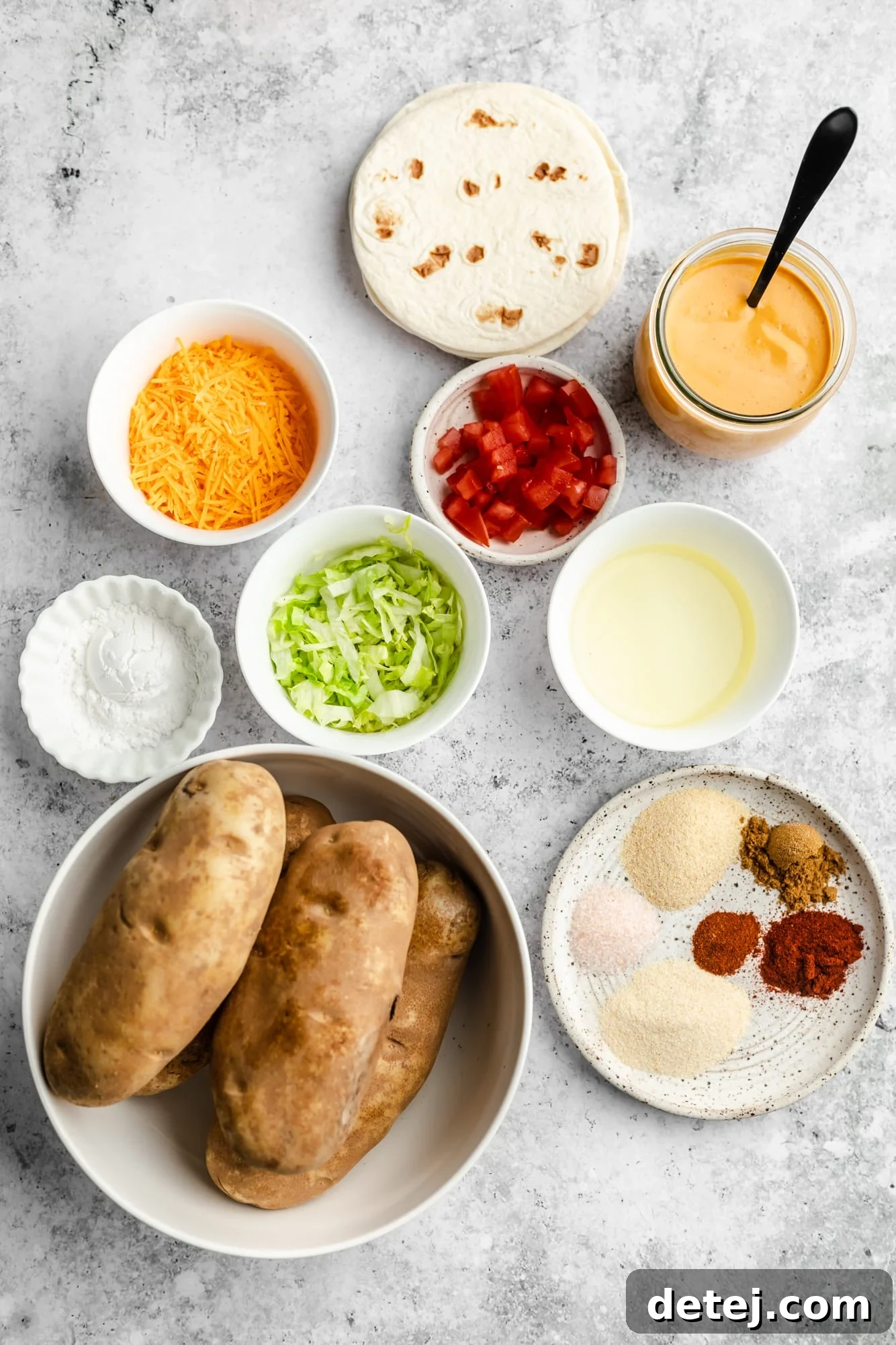 Individual white bowls filled with all the fresh ingredients needed to prepare vegan potato tacos, neatly arranged.