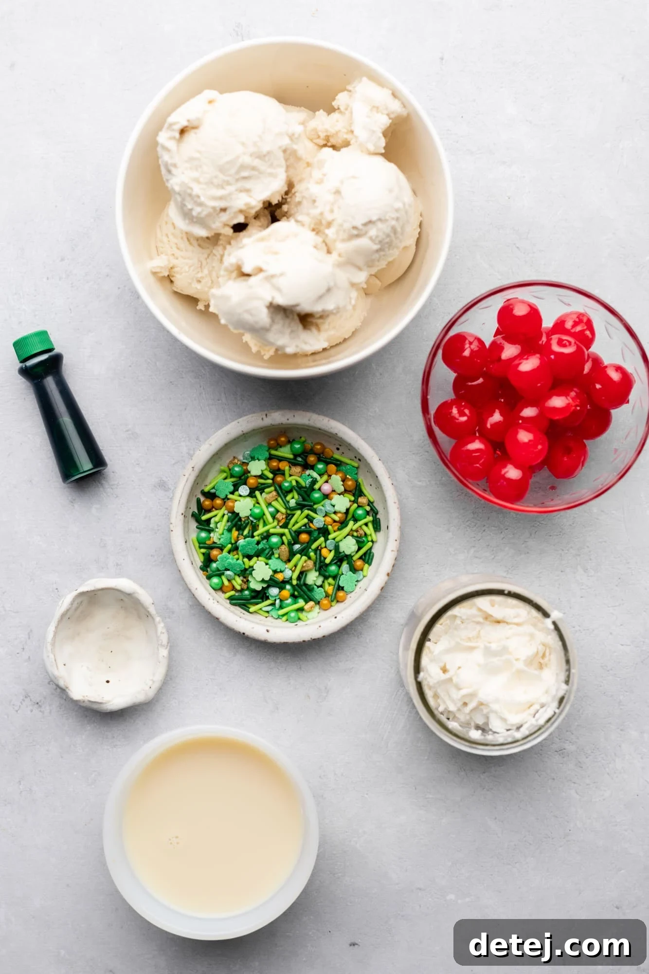 A beautiful flat lay photograph showcasing the individual ingredients for a vegan shamrock shake, neatly arranged in small white bowls, ready for blending.