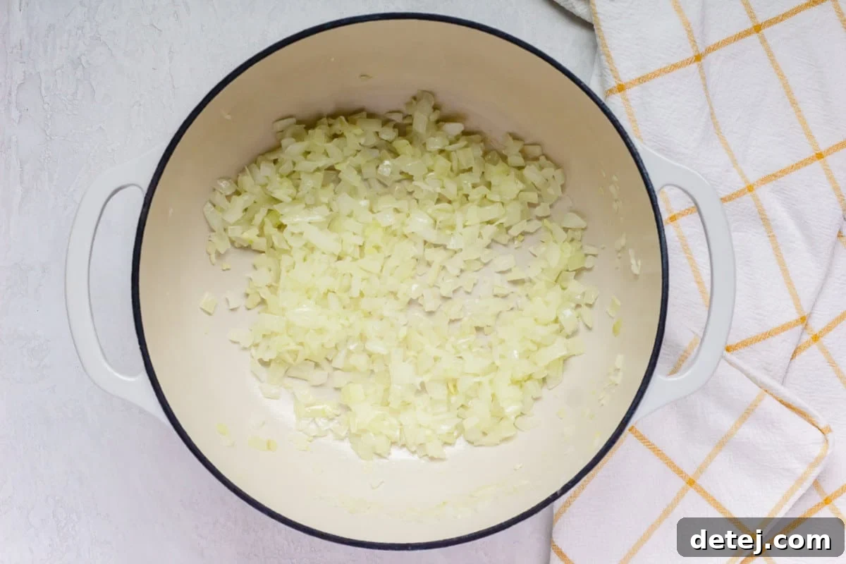 onions sauted in a white pot with yellow-white squared towel.