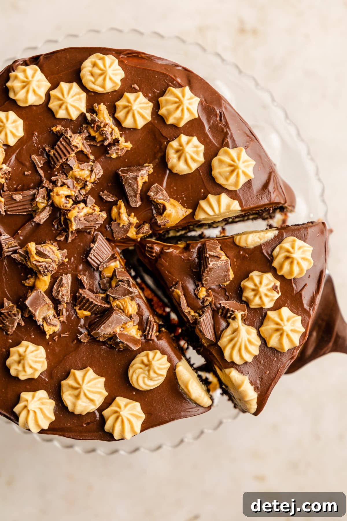 Decadent Chocolate Peanut Butter Dream 8 lifting a slice of chocolate peanut butter cake from the whole cake.