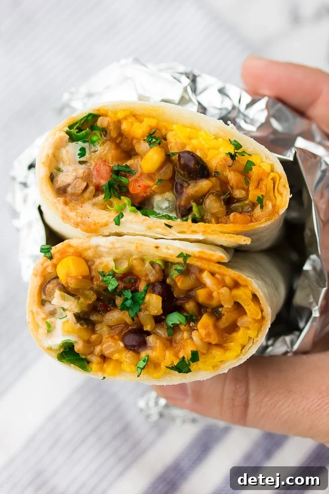 close up of a burrito with colorful filling, wrapped in foil