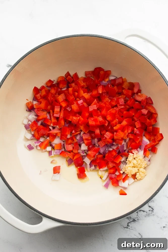 white pot with onion, red pepper and garlic