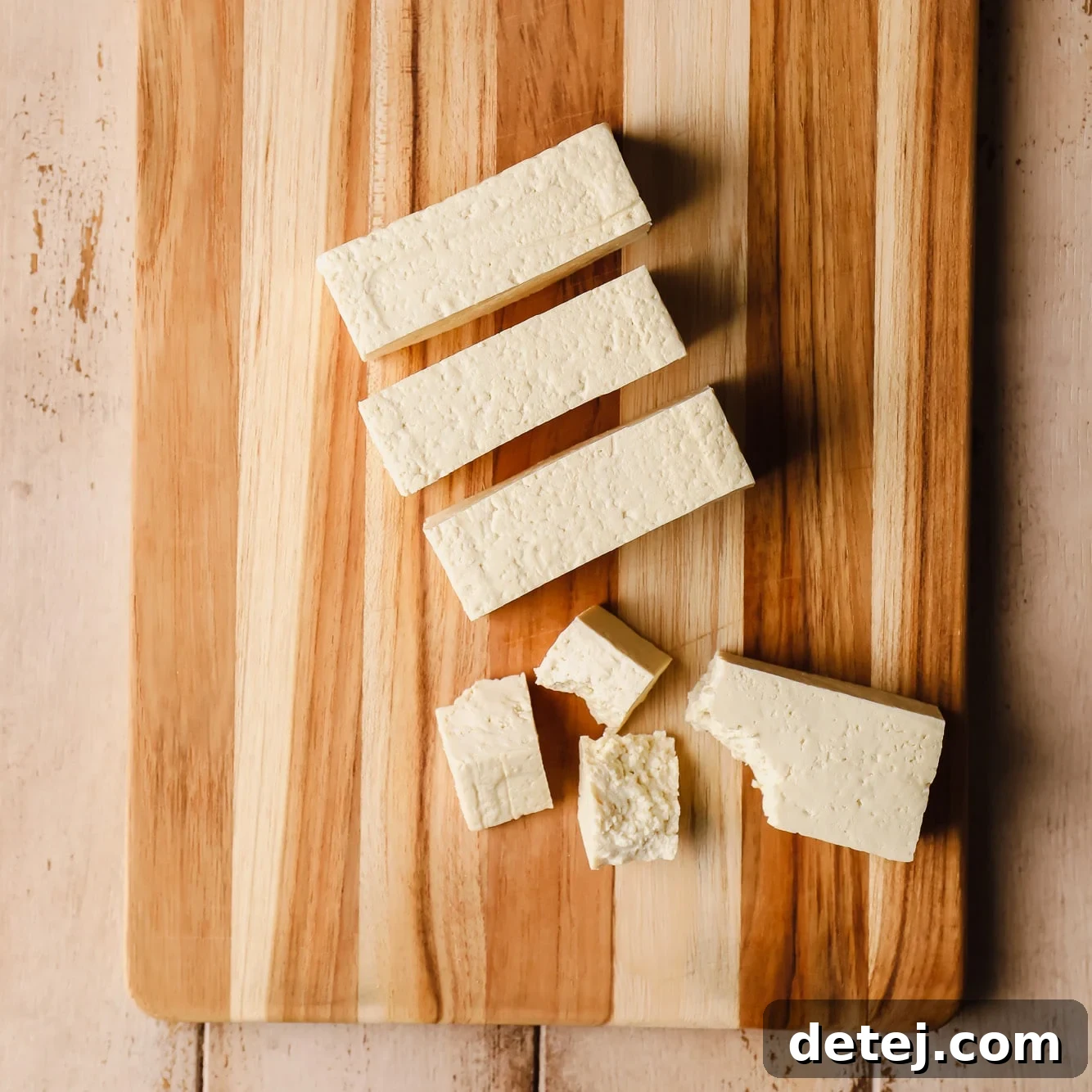 ripping a sliced tofu block into smaller pieces.