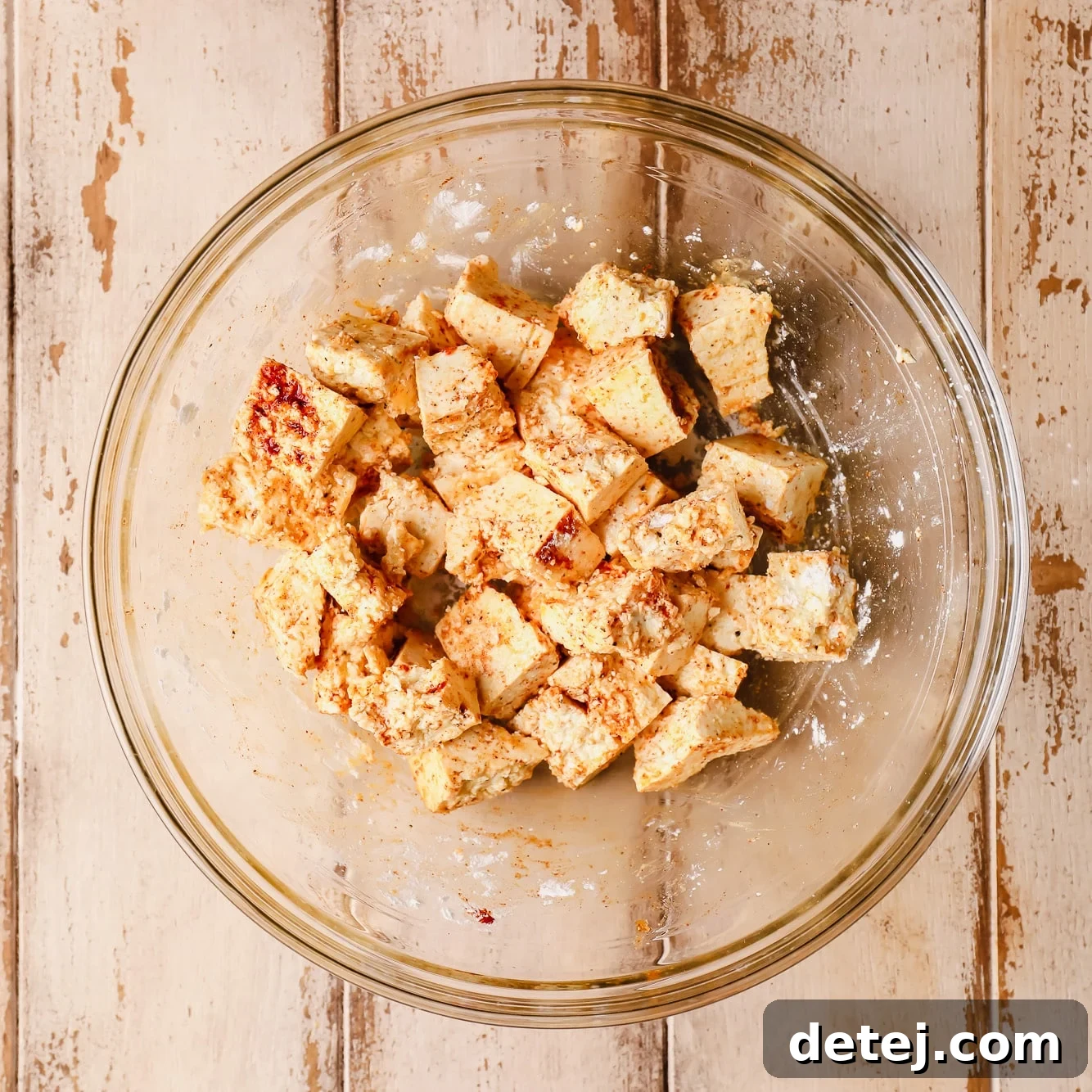 seasoned raw tofu pieces in a glass bowl.
