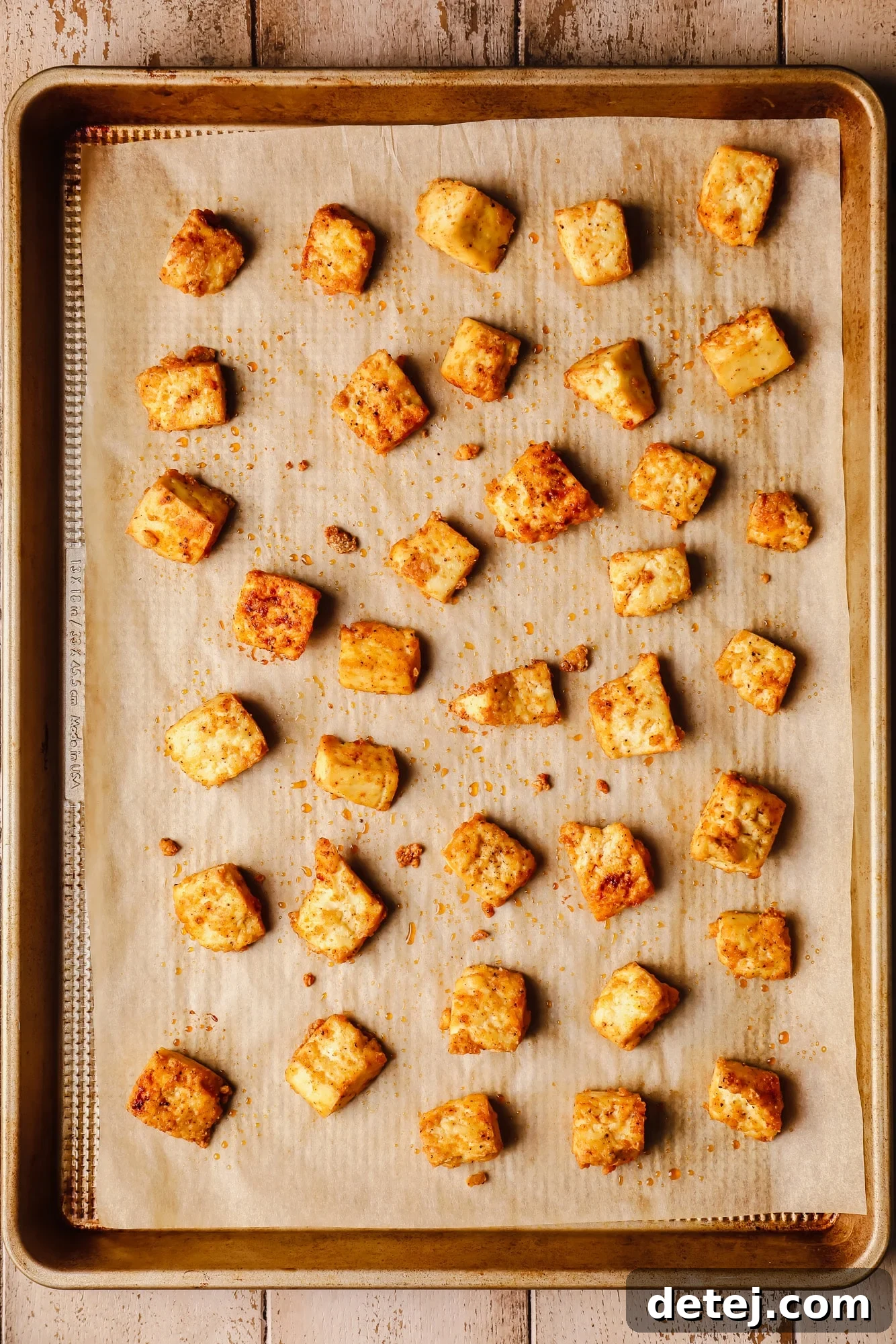 baked tofu pieces in rows on a baking sheet.