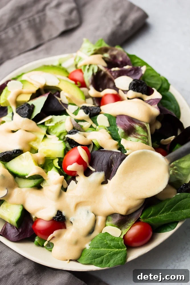 close up of creamy dressing being spooned onto salad
