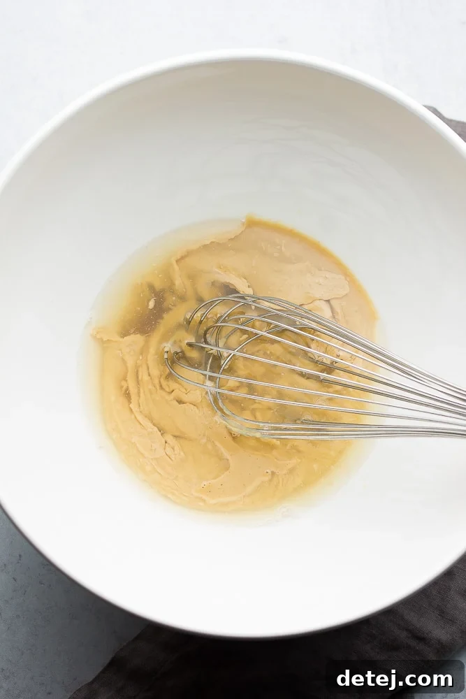 showing how to make dressing in a white bowl with whisk