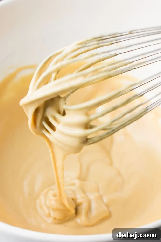 whisk in bowl of lemon tahini dressing