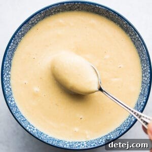 square photo of dressing in bowl with spoon
